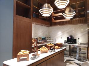 a large kitchen with some bread on a counter at L+Snow Supreme Hotel in Shanghai