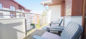 a balcony with chairs and tables on a building at Central Apartments Neptun Park 1 & Parking in Gdańsk