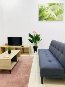 a living room with a blue couch and a tv at MiriTimesSquare DAJ#3 FREE WiFi in Miri