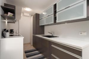 a kitchen with white and brown cabinets and a sink at Degrassi Square Apartments in Vrsar