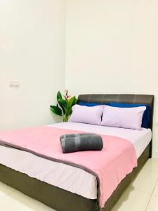 - un lit avec une couverture rose et un oreiller dans l'établissement MiriTimesSquare DAJ#3 FREE WiFi, à Miri