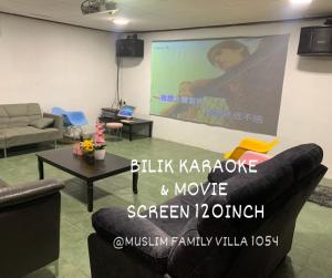 a living room with a large projection screen and a couch at A famosa resort villa 1054 in Kampong Alor Gajah
