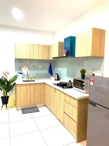 a kitchen with wooden cabinets and a refrigerator at MiriTimesSquare DAJ#3 FREE WiFi in Miri