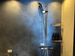 a shower with a shower head in a bathroom at Grand Mercure Beppu Bay Resort & Spa in Beppu