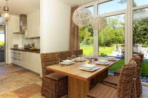 a kitchen and dining room with a wooden table and chairs at Ferienhaus am Lotsenstieg 6 in Karlshagen