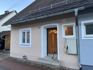 Casa blanca con puerta y ventanas marrones en Haus Erzbergblick, en Eisenerz