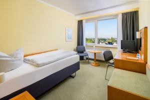 um quarto de hotel com uma cama e uma televisão em Garden Hotel Krefeld em Krefeld