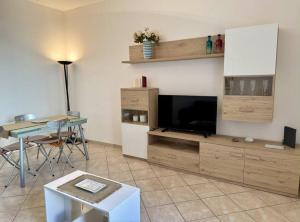 ein Wohnzimmer mit einem Flachbild-TV und einem Tisch in der Unterkunft Ilaria House in Como