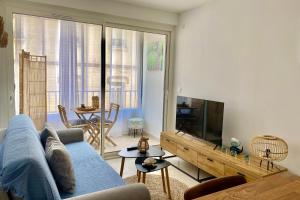 a living room with a blue couch and a tv at T2 Boheme Centre Ville Palavas Proche Plage in Palavas-les-Flots