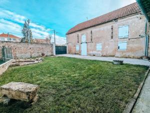 an empty yard in front of a brick building at Maison avec cour et parking clos in Fère-en-Tardenois