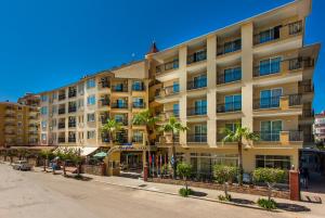 a large building with palm trees in front of it at Kleopatra Royal Palm Hotel in Alanya