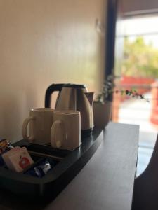 a tea kettle and coffee cups on a counter at Trattino Resorts in Panchgani