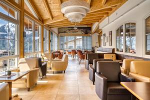 ein Restaurant mit Tischen, Stühlen und Fenstern in der Unterkunft Hotel Alpen-Royal in Jerzens