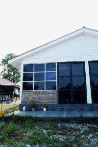 une maison avec beaucoup de fenêtres dans l'établissement Qimmy Riverside Guesthouse, à Kuala Terengganu