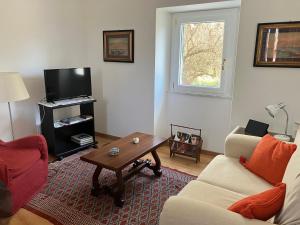 salon z kanapą i stołem w obiekcie Cascina delle Rose w mieście Sarzana