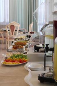 a long table with plates of food on it at Hotel Royal Plaza in Rimini