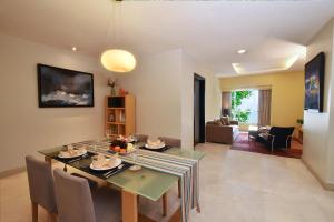 Un comedor y una sala de estar con mesa y sillas. en Somerset Berlian Jakarta, en Yakarta
