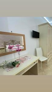 Zimmer mit einem Schreibtisch mit einem Spiegel und einem Stuhl in der Unterkunft B&B Le Ortensie in San Vito lo Capo