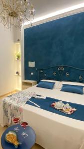 ein Schlafzimmer mit einem Bett mit zwei Gläsern Wein in der Unterkunft B&B Le Ortensie in San Vito lo Capo