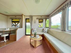 a living room with a couch and a table at Domek holenderski in Rydzewo