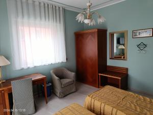 - une chambre avec un lit, un bureau et une chaise dans l'établissement Villa Mariana Bed and Breakfast, à Saluces