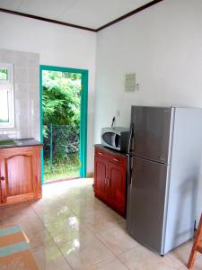 y cocina con nevera y microondas. en Fadine Self Catering en La Digue