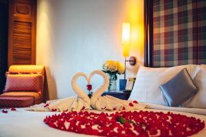two swans making a heart with roses on a bed at Hotel Cambodiana in Phnom Penh