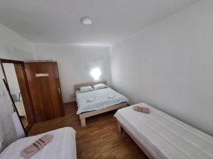 Kleines Zimmer mit 2 Betten und einem Schrank in der Unterkunft Apartmani Ružica in Višegrad