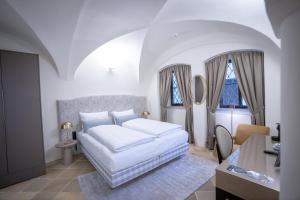 - une chambre blanche avec un lit et 2 fenêtres dans l'établissement Maxim Suites by Elias Holl, à Augsbourg