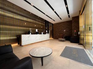 a lobby with a bar with a man standing at a counter at Wink Hotel @ Bugis in Singapore