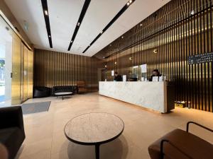 a lobby with a reception desk and people at a counter at Wink Hotel @ Bugis in Singapore
