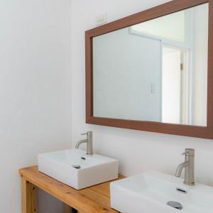 ein Badezimmer mit zwei weißen Waschbecken und einem Spiegel in der Unterkunft the Sanctuary Kohama Retreat in Kohama