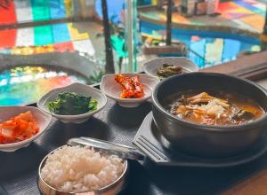 Jungheung Gold Spa & Resort في Naju: طاولة مع أطباق من الطعام وصحن من الأرز