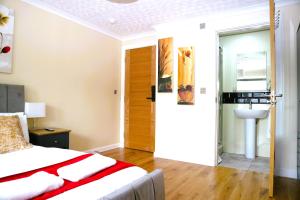 a bedroom with a bed and a bathroom with a sink at Bridge Street Guest Rooms in Tranent