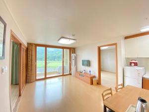 a kitchen with a dining table and a room with a window at Jungheung Gold Spa & Resort in Naju