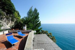 duas cadeiras azuis sentadas num passeio junto ao oceano em Felicity: Breathtaking View On Mediterranean Sea em Maiori