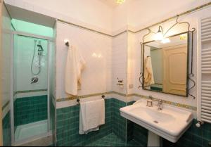 uma casa de banho com um lavatório, um chuveiro e um espelho. em Felicity: Breathtaking View On Mediterranean Sea em Maiori