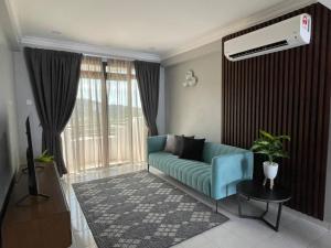 a living room with a blue couch in front of a window at Condo Istana Penthouse in langkawi in Kuah