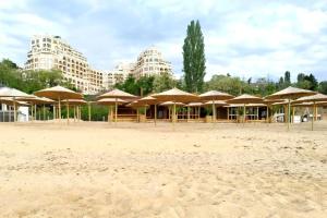 un groupe de parasols sur une plage avec des bâtiments dans l'établissement Cabacum Beach Residence - free parking, à Varna