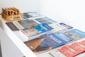 een stapel tijdschriften en boeken op een plank bij B&B Villa Mamma Grazia in San Vito dei Normanni