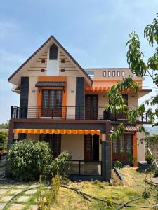 a house with a balcony on top of a yard at Casa Felicia-Adding happy moments to your diary in Ooty