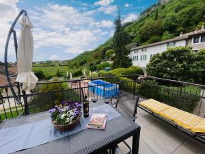 einen Balkon mit einem Tisch und einem Sonnenschirm in der Unterkunft Villetta Moscal in Affi