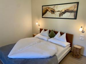 Schlafzimmer mit einem Bett mit weißer Bettwäsche und Kissen in der Unterkunft Villetta Moscal in Affi