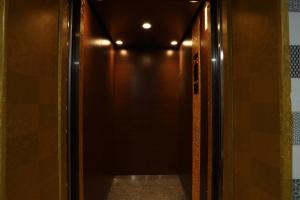 um corredor de elevador com uma parede castanha e uma porta em CAMERON KEA FARM HOTEL Islamic concept Hotel em Brinchang