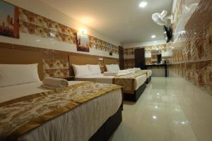 a hotel room with two beds and a kitchen at Cameron Kea Farm Hotel in Brinchang
