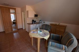 a small kitchen with a table and chairs in a room at Hotel und Ferienwohnung Rodenbäck in Neuharlingersiel