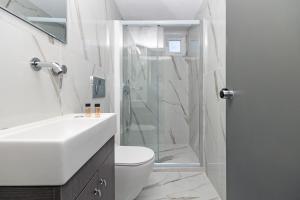 a bathroom with a shower and a toilet and a sink at Pelithea Family Resort in Corfu