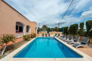 a swimming pool with lounge chairs and a house at Can Pep Ramon 2 in Sant Francesc de s'Estany