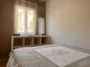 1 dormitorio con cama, ventana y espejo en Magnifique Maison Piscine et Base Nautique à 100m, en Luzech