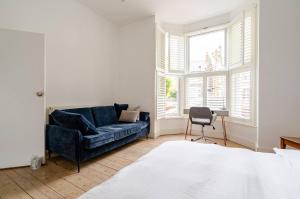 a living room with a blue couch and a chair at Blue Valley House in London